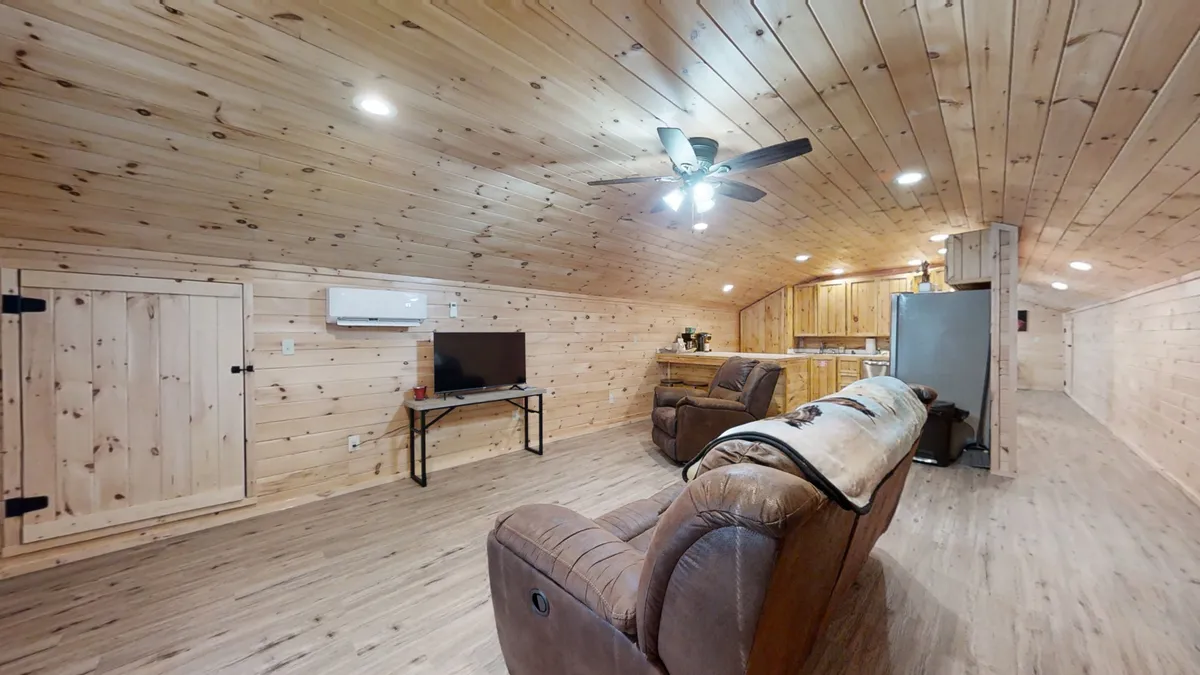 The photo features reclining chairs, a television, and wooden cabinetry, creating a relaxed atmosphere. The scene conveys a perfect spot for movie or game nights, reinforcing the sense of comfort and relaxation that awaits after a day spent exploring the area by motorcycle or trailer.